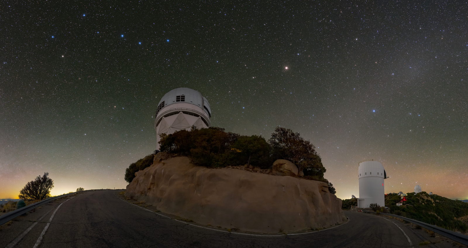 Panorámica nocturna del observatorio de Kitt Peak con las siete estrellas del Carro dibujadas en lo alto del cielo, sobre la cúpula del telescopio Mayall.