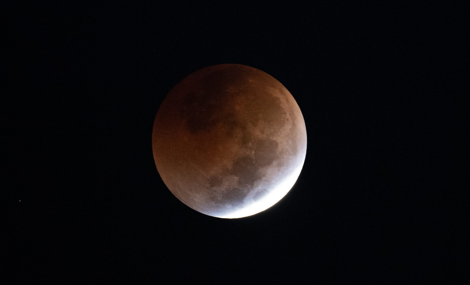 Primeros planos de la Luna durante un eclipse total, con el disco entero de color rojo oscuro.