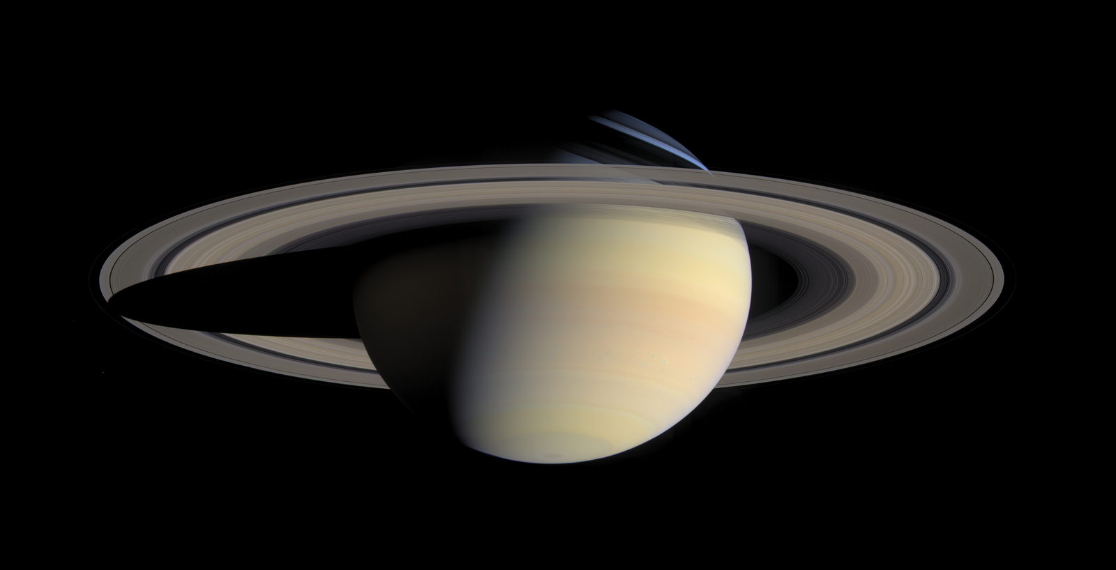Saturno entero con sus anillos abiertos, en color natural, sobre fondo negro; la sombra del planeta cae sobre los anillos por el lado izquierdo.